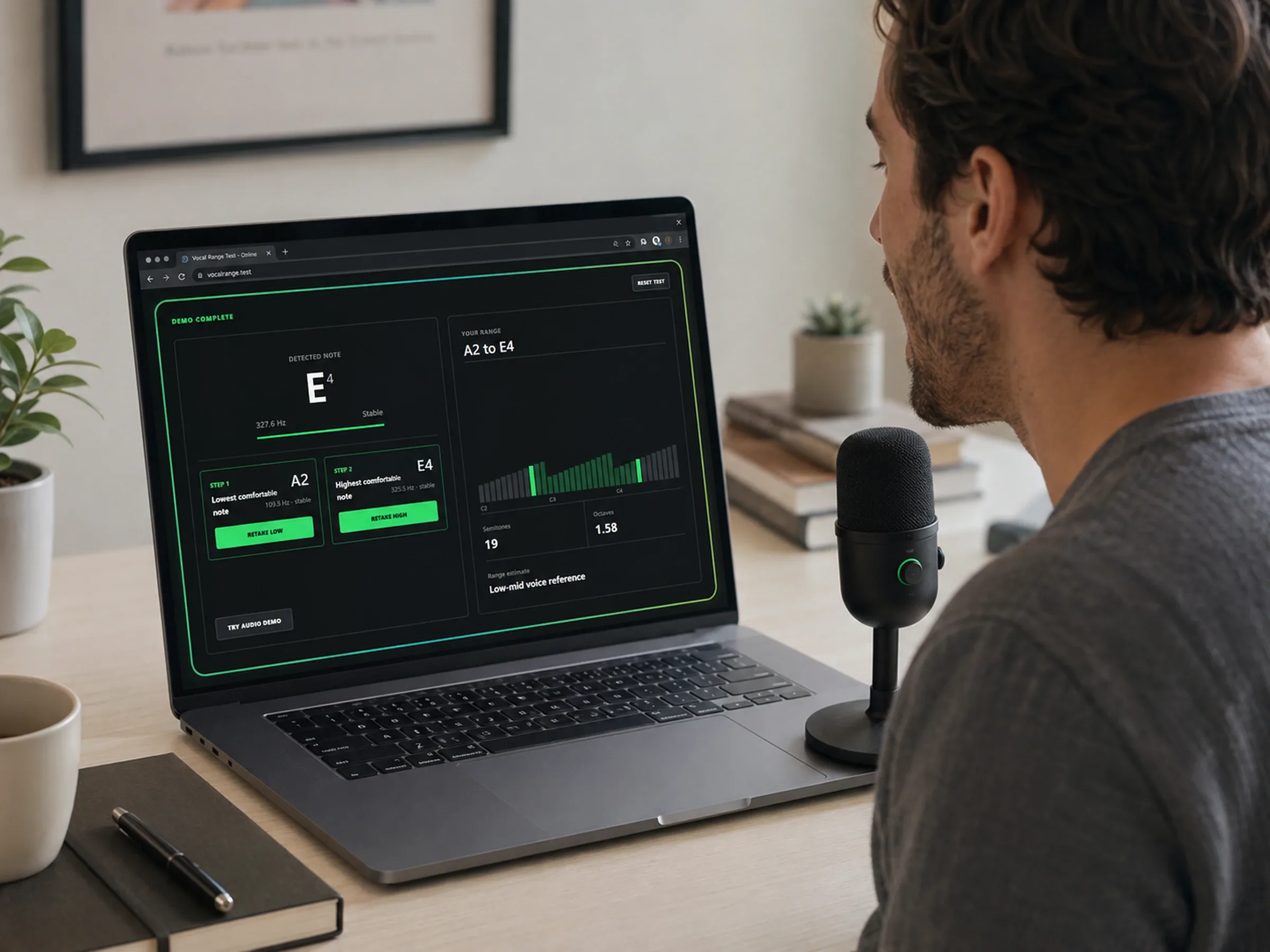 Singer viewing a completed A2-to-E4 Vocal Range Test result on a laptop beside a microphone